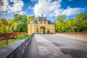 Fototapeta premium Smedenpoort, a city gate of Bruges surrounded by water.