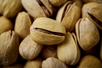 background full of delicious pistachios on an old wooden black table in a pub