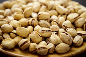 background full of delicious pistachios on an old wooden black table in a pub
