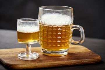 three golden delicious beers on an old black wooden table in a pub