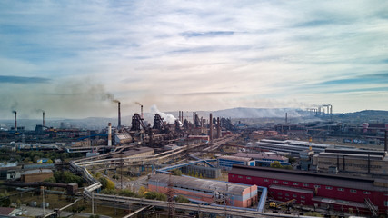Aerial panorama of industrial buildings, lot of workplaces and developed infrastructure of plant, in contrast detrimental nature impact, atmosphere emissions, air pollution; unhealthy lifestyle; Ural
