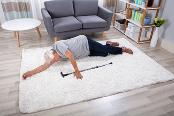 Unconscious Senior Man Lying On Carpet