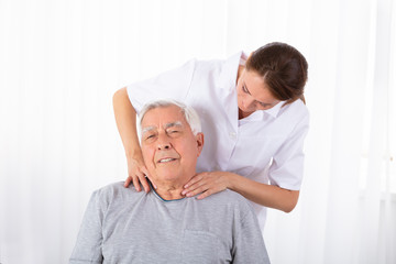 Obraz premium Physiotherapist Massaging Senior Man's Shoulder