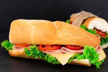 Big sandwich with meat and cheese on dark background