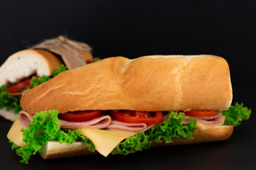 Big sandwich with meat and cheese on dark background