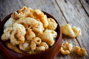 Chicharron - deep fried pork rinds, crispy pork skin pieces in wooden bowl, traditional mexican snack