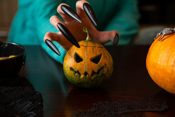 Photo of man's hands with pumpkin jack sitting at wooden table