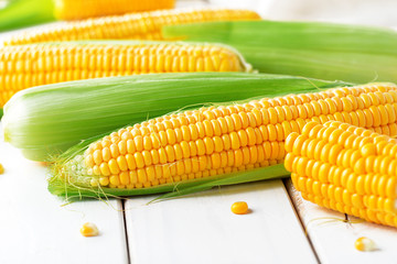 Raw corn on a wooden table