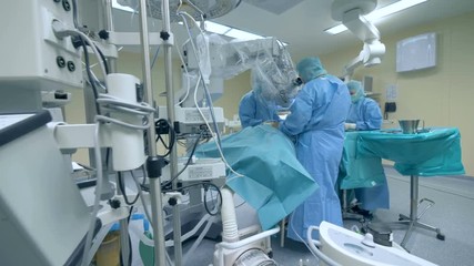 Orthopaedic surgery in a room. A doctor and a nurse performing a surgery at a clinic. Innovative medicine concept. - Powered by Adobe