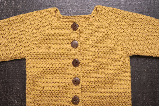 Crocheted Yellow Cardigan On A Black Background