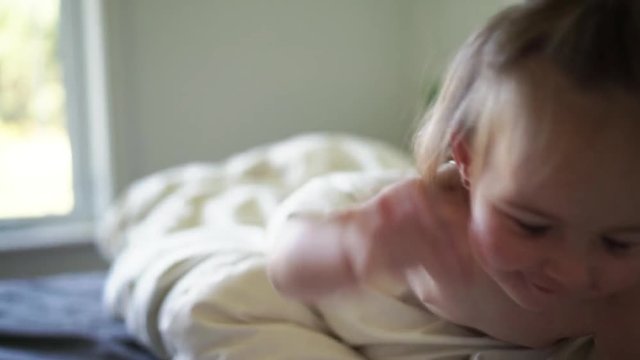 Cute little baby girl on bed at home