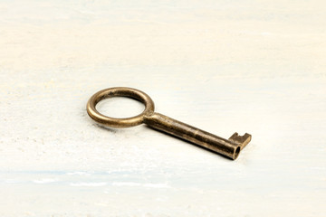 A photo of a vintage key on a light background with a place for text