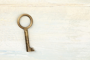 A top shot of a vintage key on light background with a place for text