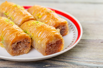 Traditional arabic dessert baklava with cashew, walnuts and cardamom with an eucalyptus branch on a wooden table