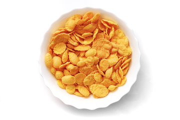 closeup of corn flakes in a white bowl isolated on white background, top view
