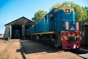 Obraz premium Old blue diesel locomotive leaves the depot. Railway transport
