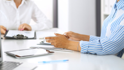Group of business people at meeting in office, close-up. Team of two women discussing deal. Negotiation concept