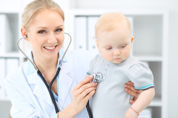 Doctor and patient in hospital. Little girl is being examined by pediatrician with stethoscope. Medicine and health care