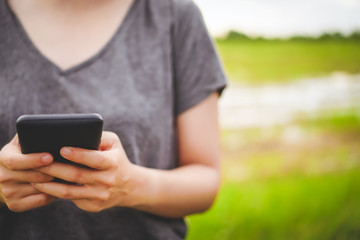 Woman hand using smartphone and laptop with cafe shop sunlight  shade to object beautiful background.