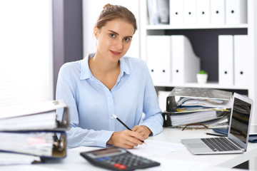 Fototapeta na wymiar Woman bookkeeper or financial inspector calculating or checking balance, making report. Internal Revenue Service at work with financial document. Tax and audit concept