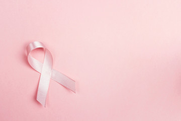 Pink ribbon on pink background withcopy space. Breast cancer awareness symbol.