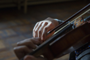 Hand on the strings of a violin