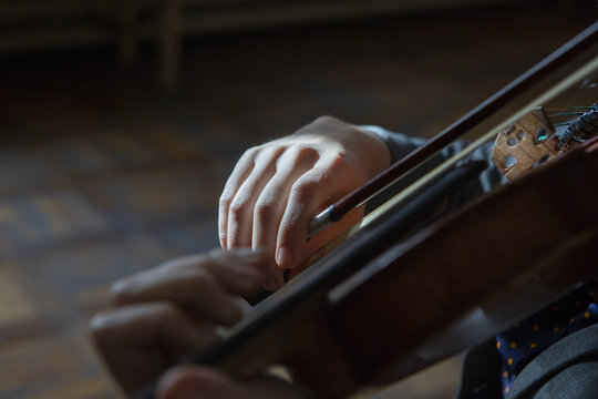 Hand on the strings of a violin