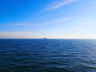 Travel and transportation concept. In the winter morning, the ship is sailing alone in the deep blue sea. Selective focus and copy space.