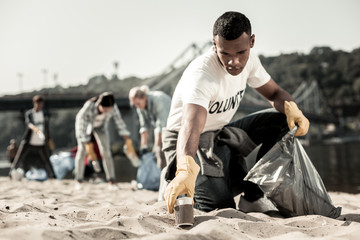 Joyful the process. Handsome responsible dark-haired student enjoying the process of volunteering...