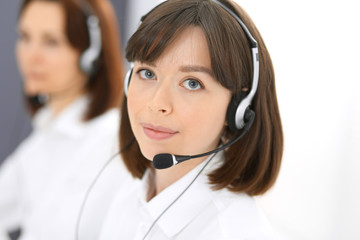 Call center. Group of operators at work. Focus on young brunette woman. Business  concept