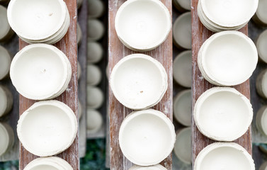 Handmade white clay pots dry on wooden planks. Top view.  Workshop, manufactory interior