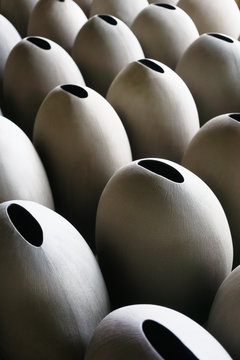 Handmade grey clay vases pattern. Workshop, manufactory. Natural light