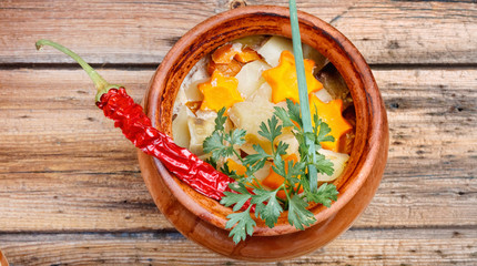 Traditional rustic home  gulyas, with raw vegetables and spices in clay pots on  wooden table.