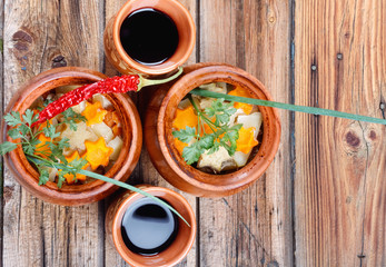 Traditional rustic home  gulyas, with raw vegetables and spices in clay pots on  wooden table.