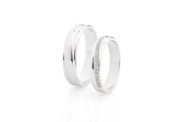 Pair of silver wedding rings with diamonds isolated on white background