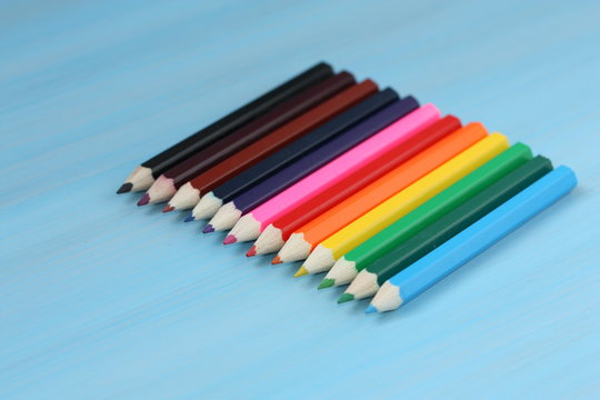 Colored pencils on blue background.