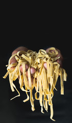 frische ungekochte Pasta Nudeln in Händen gehalten und präsentiert als Nahaufnahme mit negativem...