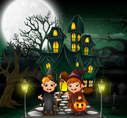 Couple witch in front of the hounted house with full moon background