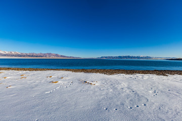   The frozen Sailimu lake with snow mountain background at Yili, Xinjiang of China