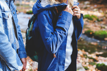 Blue denim jacket and parka. Clothing for the camping trip. Hiking clothes. Two young girls friends walking in the autumn forest. Walk in the woods at fall. © NesolenayaAleksandra