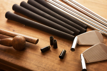 Golf club making. Golf club components on a work desk or work bench. grips, shaft, ferrules and,...
