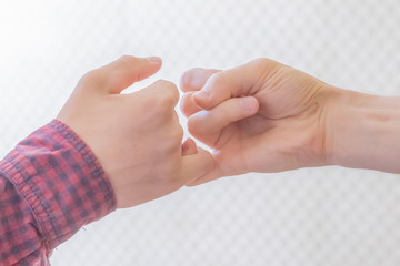 two people hand hook little fingers together and swear friendship f