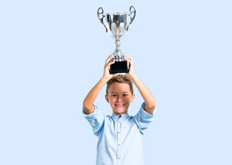 Little kid holding a trophy on color baackground