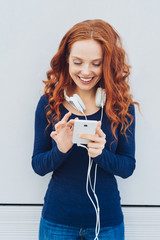 Pretty young redhead woman listening to music