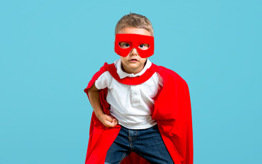 Fototapeta na wymiar Little kid dressed like superhero on color baackground