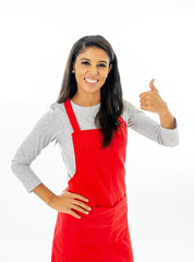 Portrait of a happy attractive woman wearing a red apron making thumb up gesture