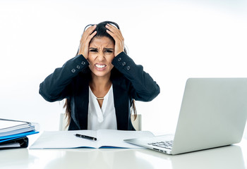 Desperate beautiful young businesswoman working on her laptop going crazy with loads of work