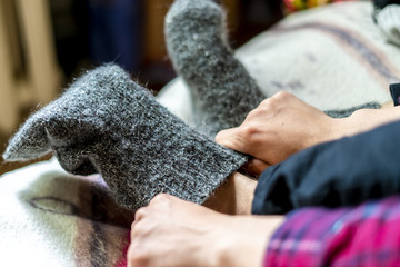 close up person wearing and put on warm wool socks on cold winter day f