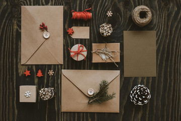 Christmas package. Christmas cards, gifts and christmas decoration on wooden table, top view