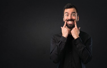 Happy handsome man with beard on black background